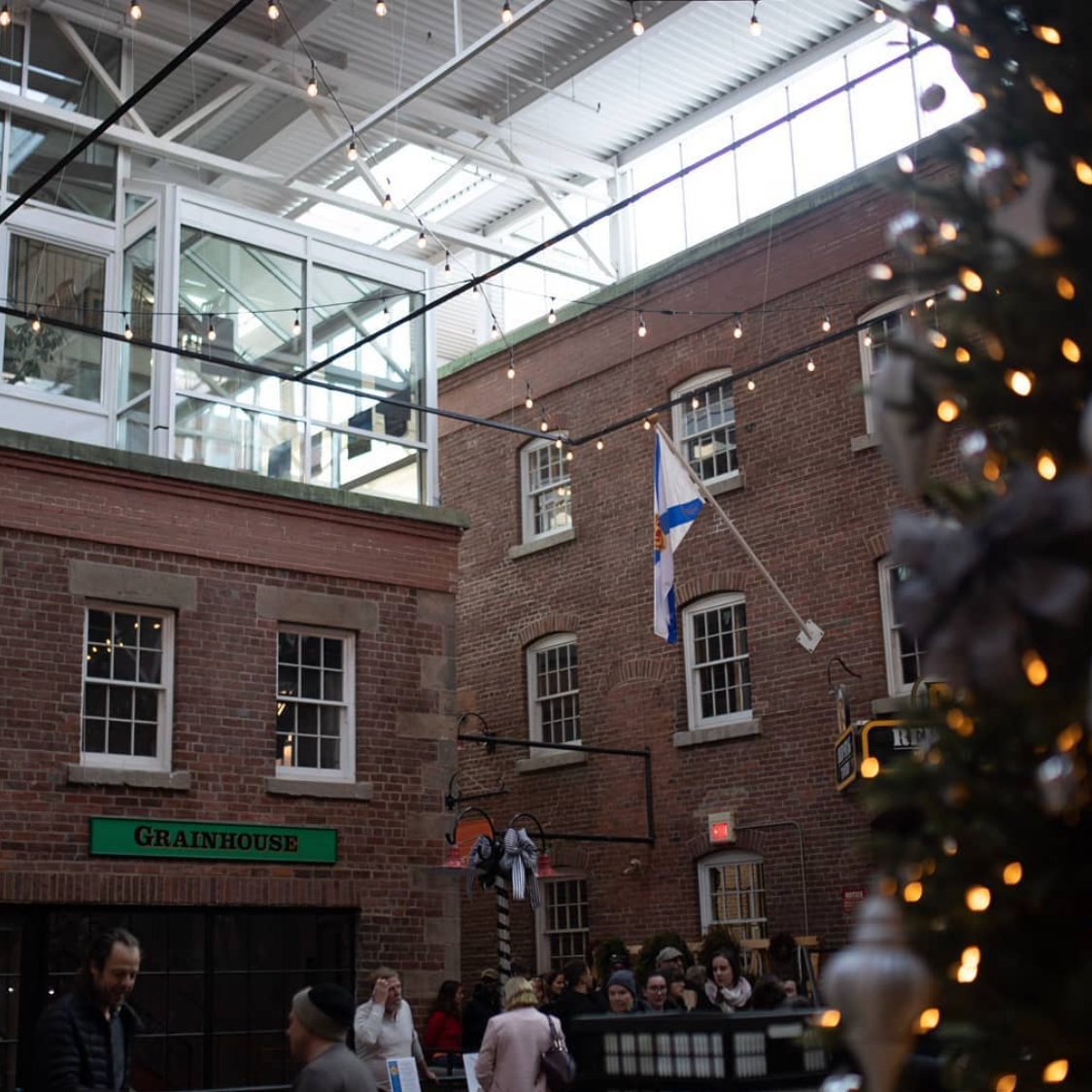 A large, open courtyard with brick walls and string lights